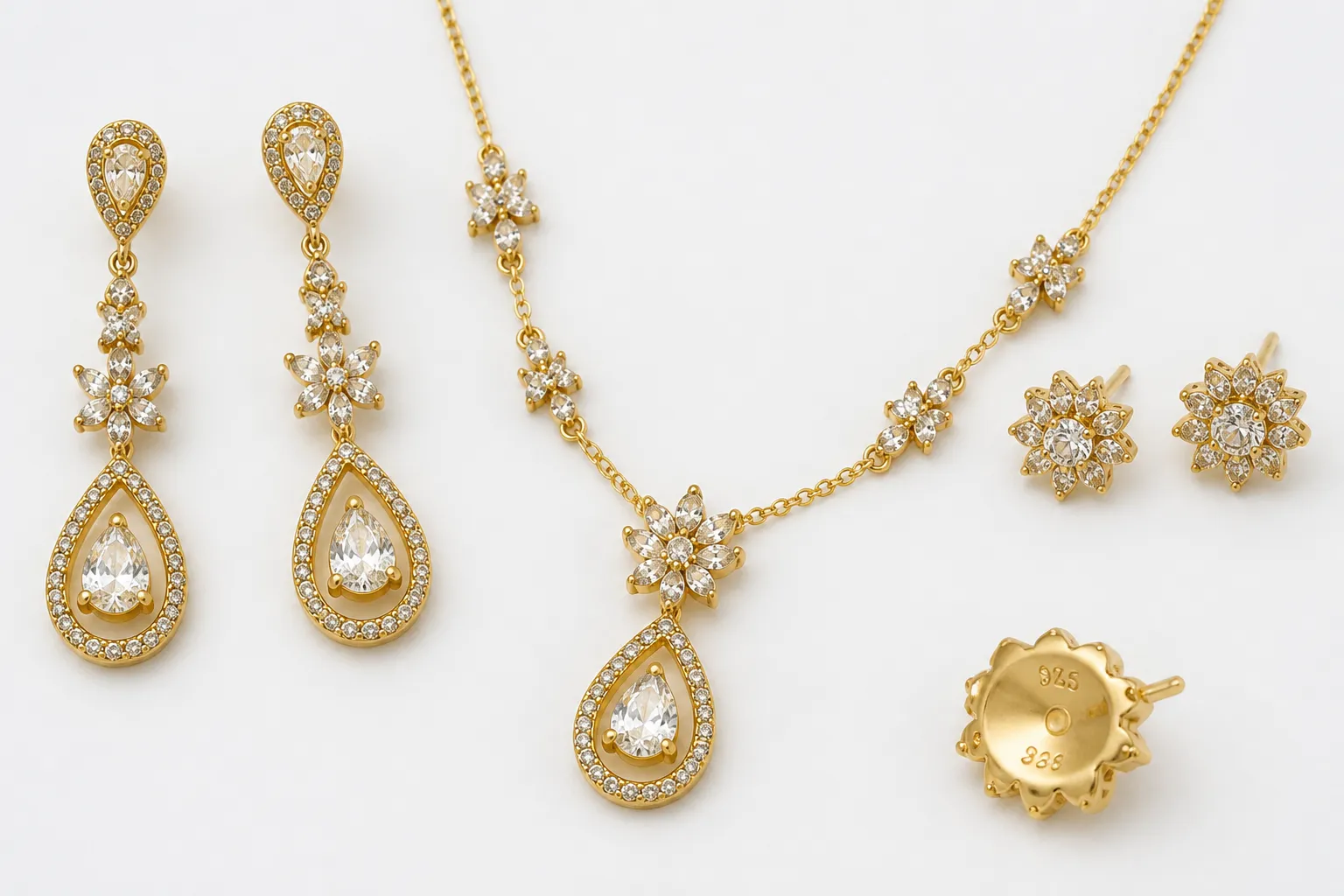 925 gold - مجموعة من مجوهرات الذهب 925 تشمل أقراط متدلية وطقم عقد وأقراط مسمار على خلفية بيضاء ناصعة، مع ختم 925 مرئي بوضوح على أحد القطع