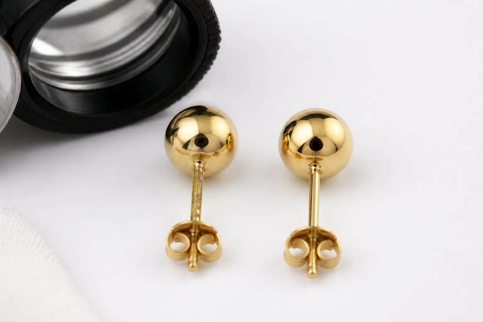 gold stud earrings - Side-by-side comparison photo showing a rejected gold stud earring (visible plating peel on the post) next to an approved unit with consistent finish, annotated with QC inspection criteria labels — illustrating the value of in-house quality verification before shipment