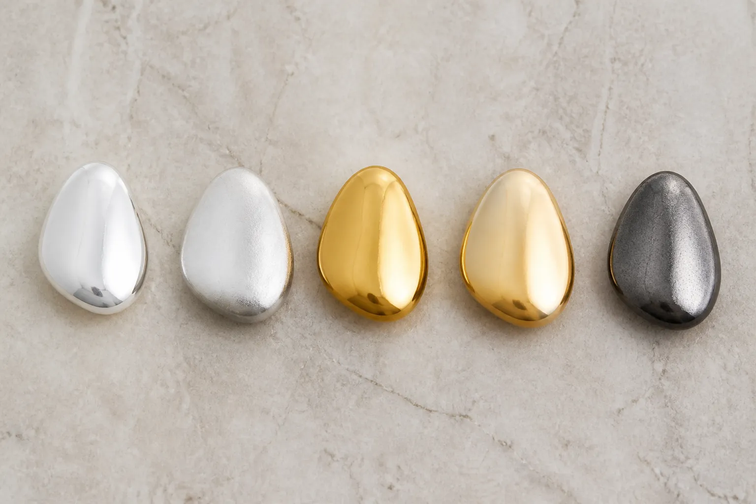poinçon argent - Tableau de comparaison visuelle côte à côte de cinq échantillons de bijoux — argent 925, argent plaqué, acier inoxydable PVD or, laiton doré, zamak — étiquetés avec leur finition respective