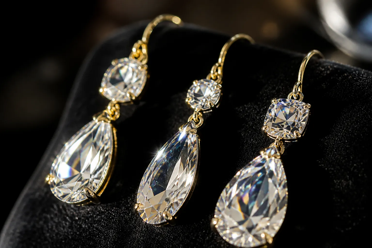 swarovski pendientes - Primer plano fotorrealista de varios pendientes de gota con cristales Swarovski sobre superficie de terciopelo negro, mostrando la refracción de luz característica del cristal cortado de precisión