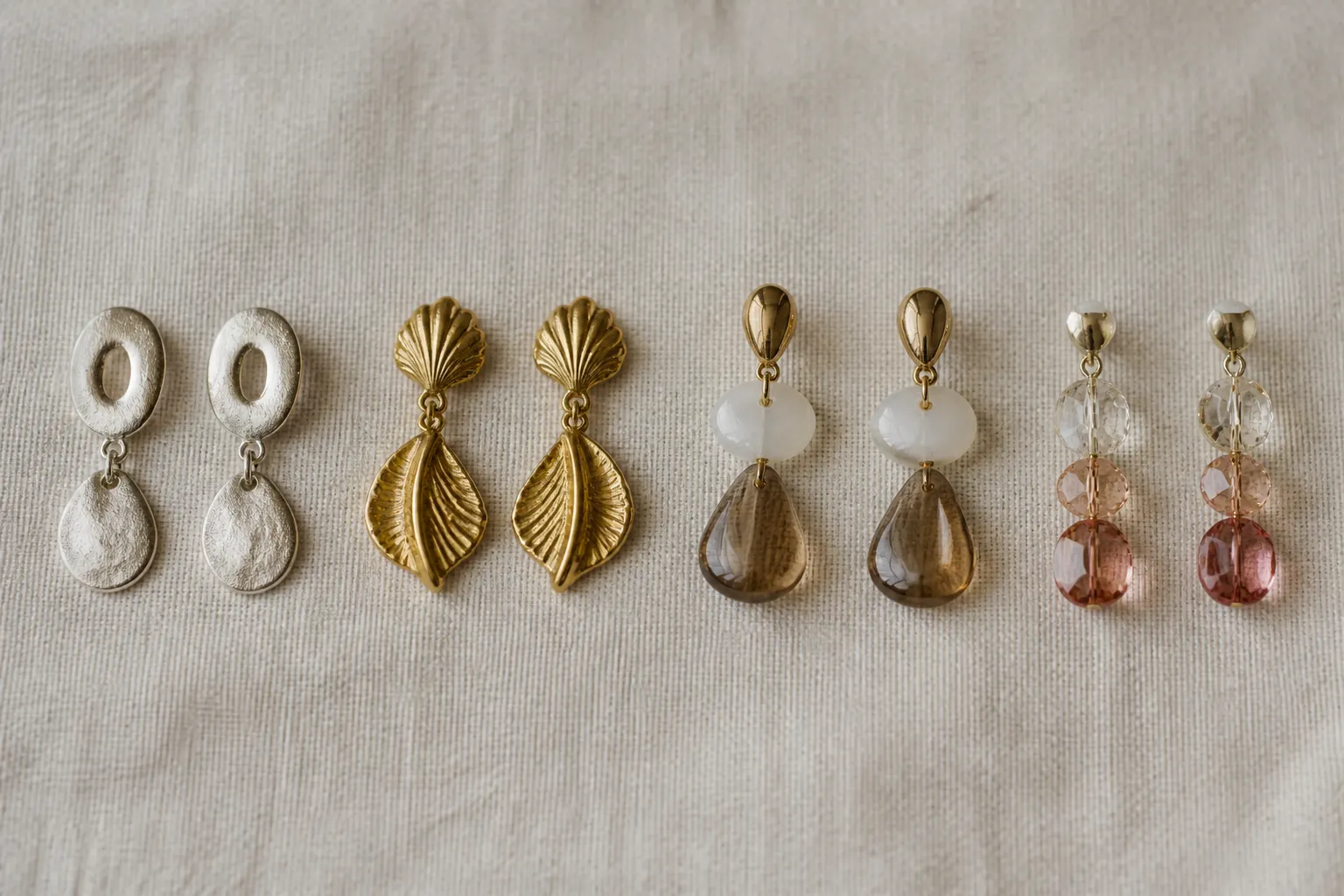 cyclade argent - Comparaison visuelle côte à côte de quatre finitions de boucles d'oreilles : argent cycladique, doré vintage, bicolore verre et cristal gradient — présentation flat lay sur fond neutre