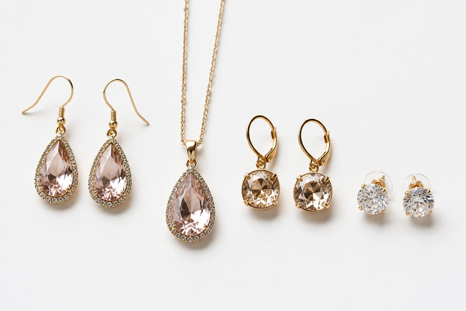custom jewelry - Side-by-side flat-lay of fashion jewelry alternatives — drop earrings, crystal necklace sets, rhinestone studs — showing variety of style options buyers can source beyond traditional custom jewelry