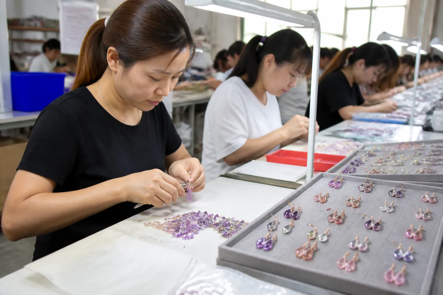 manège à bijoux - Atelier de fabrication de bijoux fantaisie en Chine — ouvrières assemblant des boucles d'oreilles avec cristaux gradient sur une chaîne de production contrôlée QC
