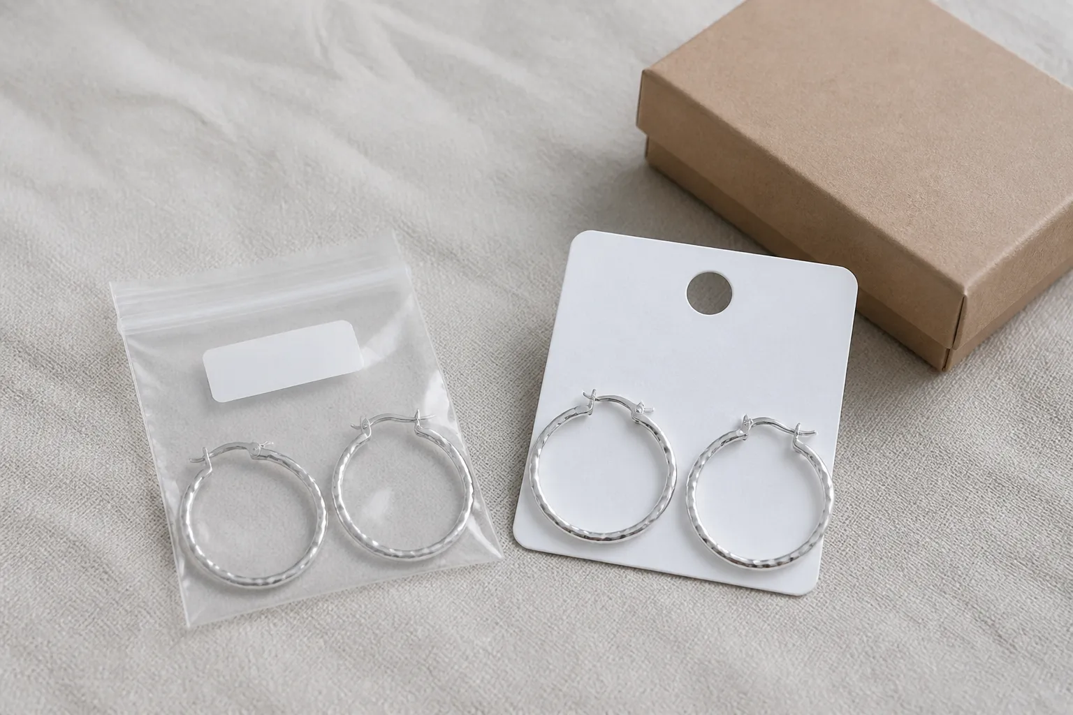 custom jewelry - Side-by-side flatlay of two identical earring silhouettes — one with generic wholesale packaging and one with custom private-label hang tags and branded box, showing the contrast in brand presentation