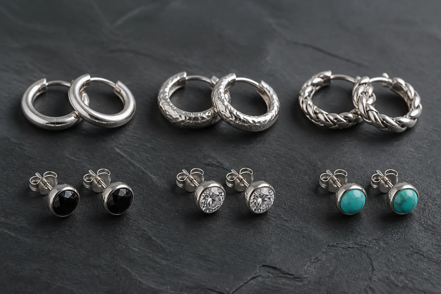 pendientes hombre plata - Selección de pendientes hombre plata sobre fondo oscuro — desde aros lisos hasta diseños con piedras — mostrando variedad de estilos y acabados disponibles en compra al por mayor