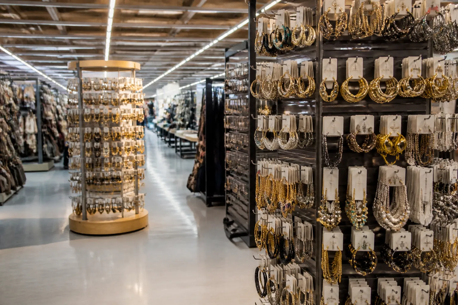le manège à bijoux leclerc - Rayon bijouterie fantaisie d'un hypermarché français avec présentoirs tournants, boucles d'oreilles et colliers en exposition, éclairage vitrine