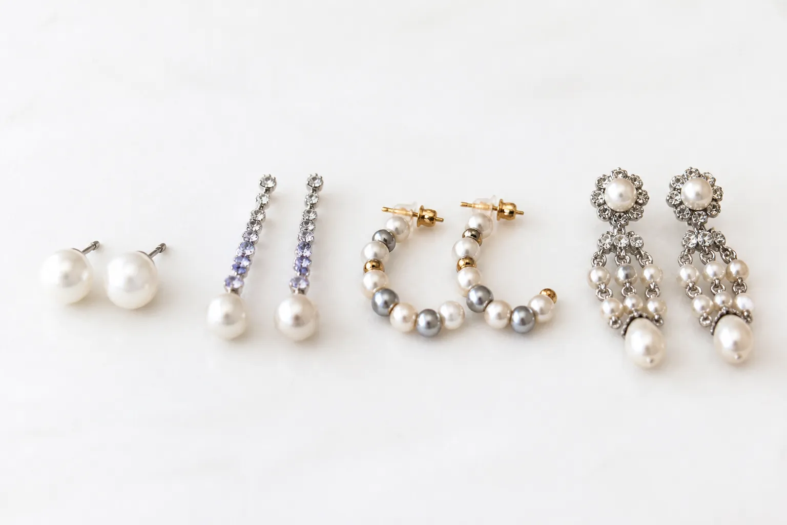 ohrringe perlen - Stilisiertes Sortimentsbild zeigt nebeneinander: klassische Perlen-Studs, Gradient-Kristall-Drop-Ohrringe, Two-Tone-Glasperlen-Creolen und Vintage-Strass-Chandelier – beschriftet mit den jeweiligen Stilkategorien