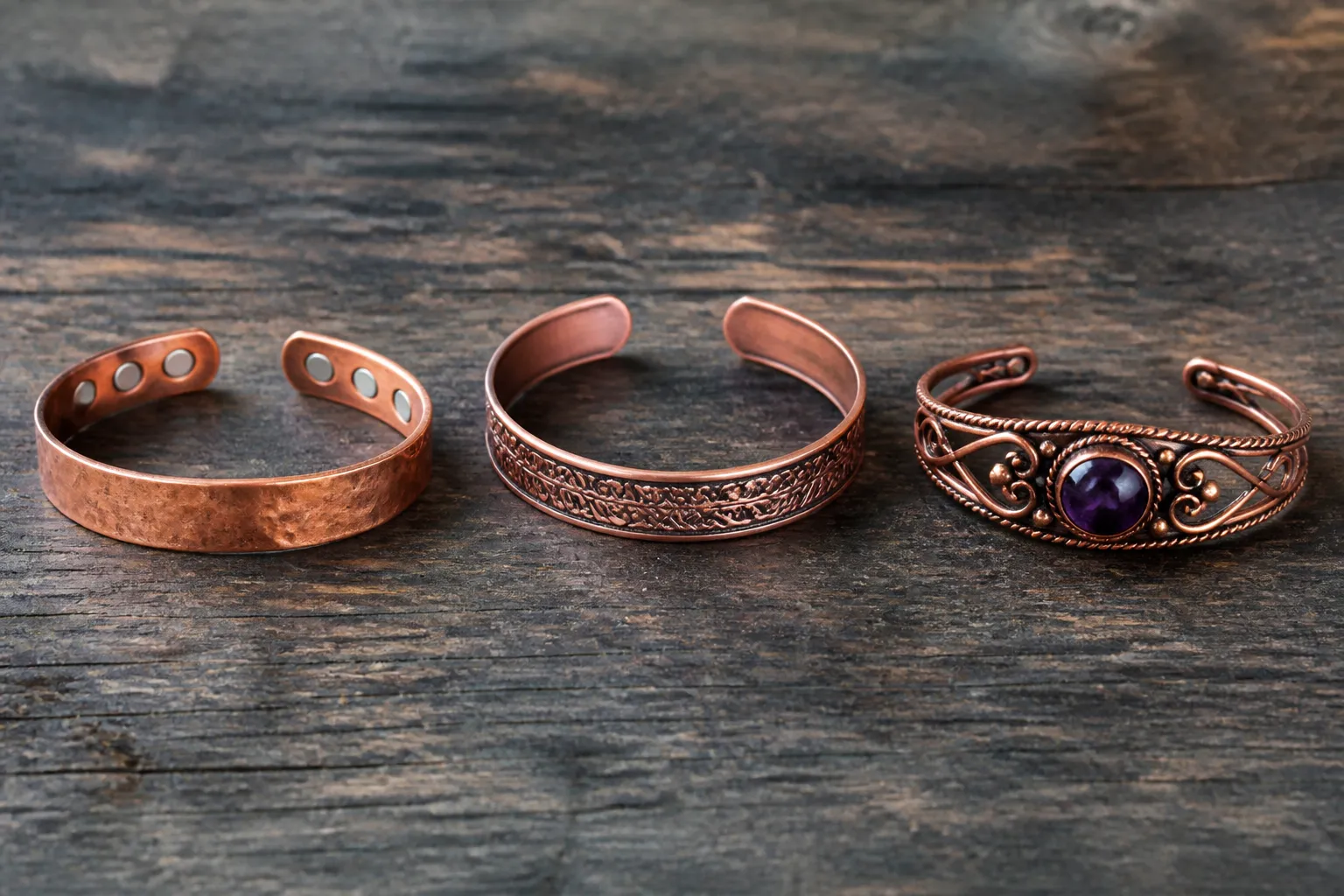 pulsera de cobre - Fotografía editorial de tres estilos distintos de pulsera de cobre sobre superficie de madera oscura — pulsera con imán, pulsera banda decorativa y pulsera con piedras semipreciosas, con etiquetas que identifican cada tipo