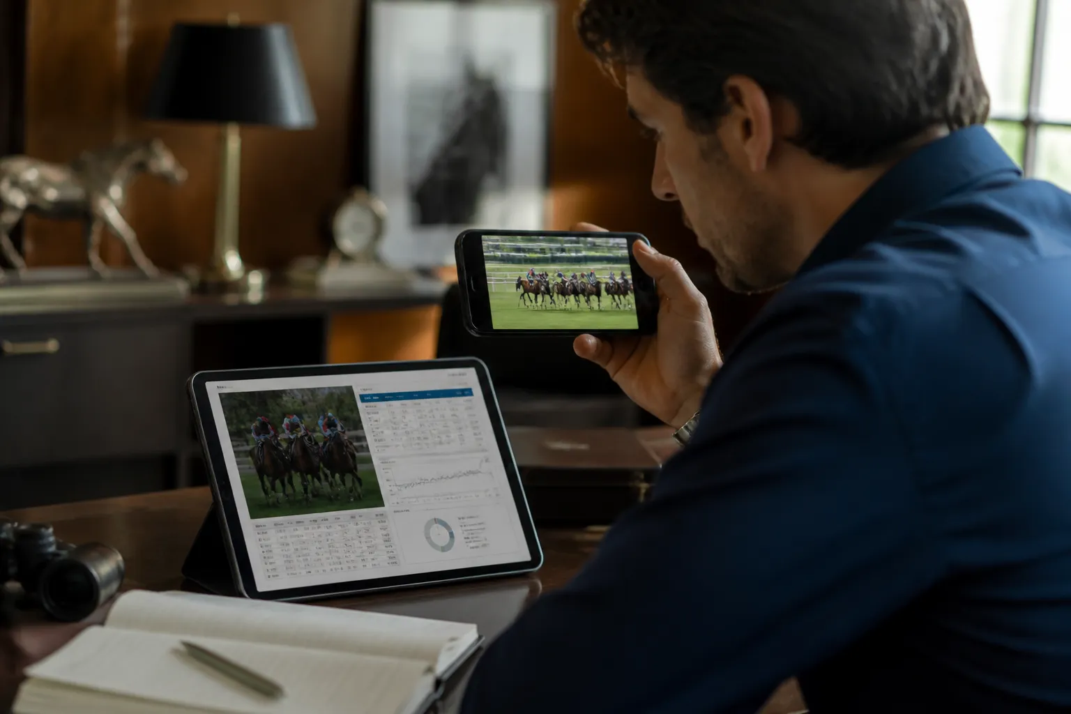 pronostic en or - Photo éditoriale d'un parieur professionnel analysant simultanément un article 'Base en Or' sur tablette et un replay de course sur smartphone pour croiser les données