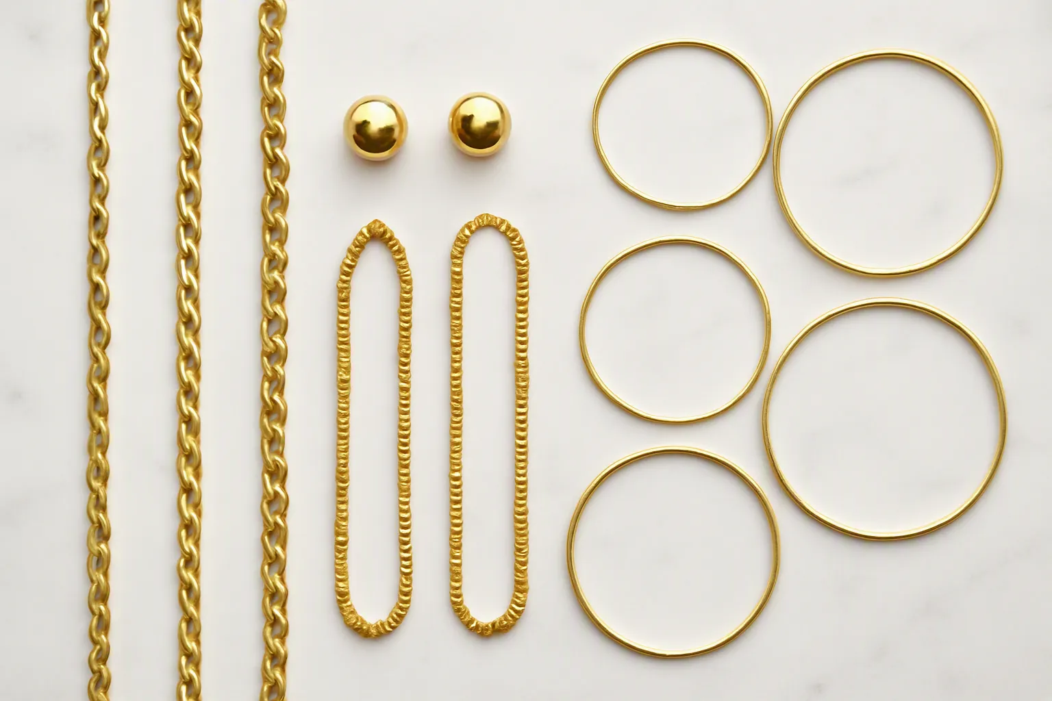 cosmetic jewelry wholesale - Photorealistic flat-lay of a curated collection of cosmetic jewelry pieces — gold-toned necklaces, stud earrings, and bangles arranged on a white marble surface, professional product photography, even studio lighting, no props
