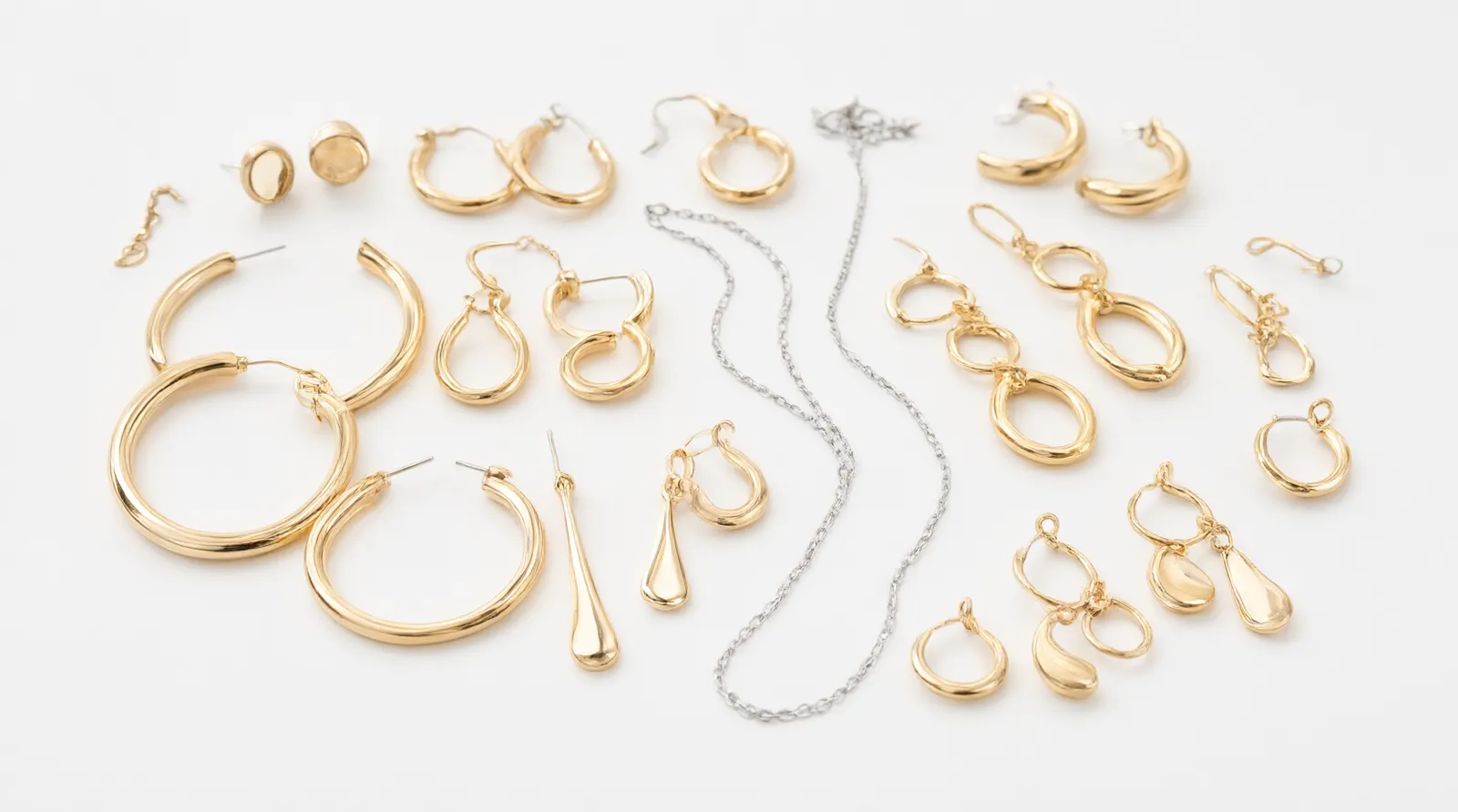 schmuck für damen - Produktbild einer kuratierten Auswahl von vergoldeten Damen-Ohrringen und einer Silberkette auf weißem Hintergrund – repräsentativ für ein Fashion-Jewelry-Sortiment im Großhandel