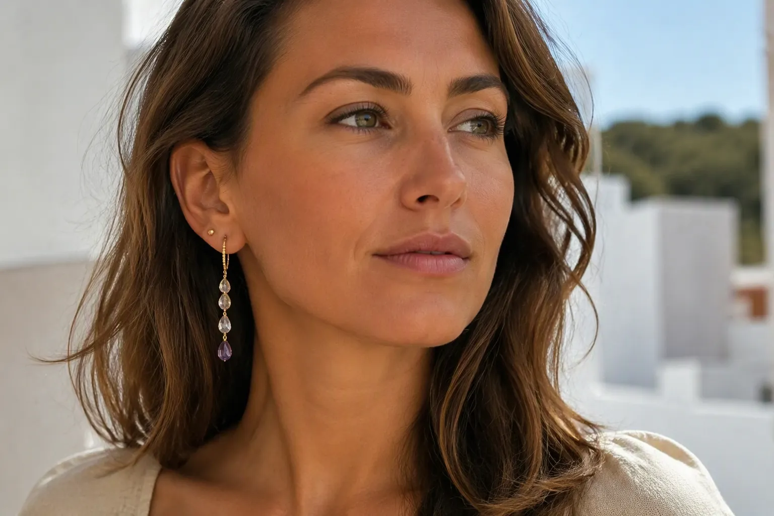 pendientes bañados en oro - Fotografía editorial de mujer con pendientes dorados tipo drop de cristal degradado y pendientes de bebe tipo stud dorados pequeños, mostrando versatilidad de uso entre estilos de collar y aretes a juego