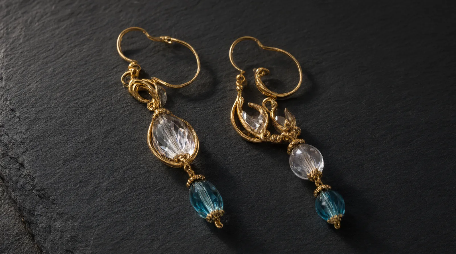 pendientes dorados grandes - Fotografía editorial mostrando una selección de pendientes dorados grandes sobre un fondo oscuro, destacando diferentes texturas como cristal degradado, cuentas de vidrio bicolor y acabados bañados en oro